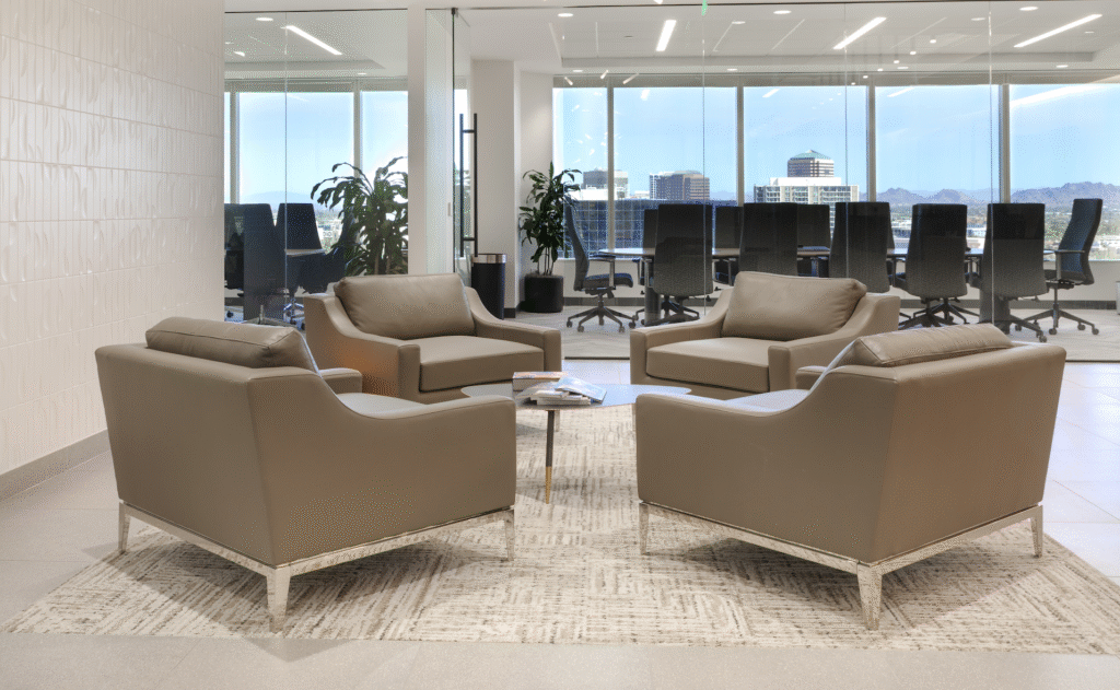The firm's lobby in Midtown Phoenix: leather chairs around a low table, with Midtown and the mountains through the windows